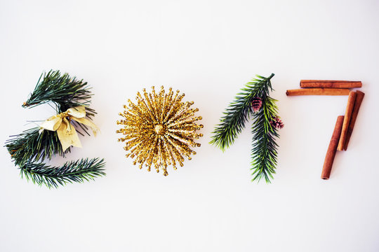 2017 text made with green pine, cinnamon and golden christmas toy