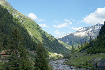 Fototapeta na wymiar Berglandschaft in Graubünden, Schweiz/Blick in ein Tal mit einem Gebirgsbach, hohe Berge teilweise mit Schnee, Landschaft in Graubünden