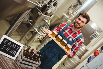 Portrait of manufacturer holding beer samples