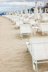 Rows of closed umbrellas and deckchairs on the empty beach
