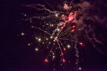 Ein farbenprächtiges Feuerwerk leuchtet am dunklen Nachthimmel bei einer Party