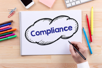 Man with a Notepad written Compliance Concept