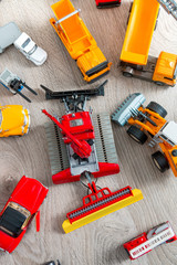Set of various yellow, red and white car toy on grey wooden background. Top view. Collection.