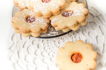 Homemade apricot jam Linzer with icing sugar on the white table close up