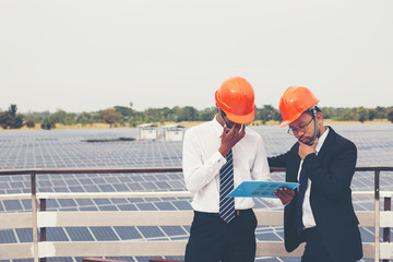 engineer working on checking and maintenance equipment at industry solar power; two engineer discussion plan to find problem of solar panel
