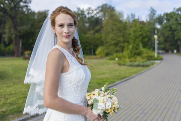 Fototapeta na wymiar Redheaded girl in white long dress under the open sky