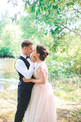 Groom and bride together. couple hugging. Wedding day. Beautiful bride and elegant groom walking after wedding ceremony. Luxury bridal dress and bouquet of flowers. Bride and groom at wedding day