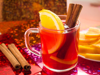 Transparent cup of tea with citrus, cinnamon and orange