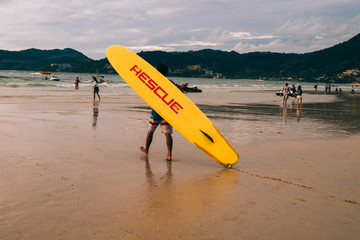 Lifeguard with vivid yellow surfboard on duty