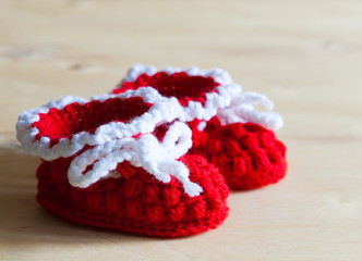 Fototapeta na wymiar Knitting. Christmas baby's bootees, close up