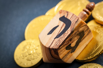 Stacks of Chanukah coins, gelt, large dreidel the traditional Jewish toy, a spinning top used for Hanukkah with copy space © Victor Moussa