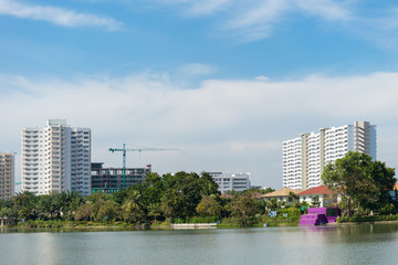 Fototapeta premium Resident building, condominium some building under construction near park, water pool in foreground and blue sky