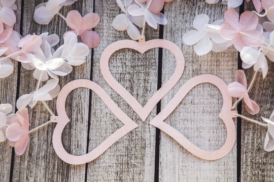 Розовые и белые сердечки и цветы на деревянном столе на День Святого Валентина