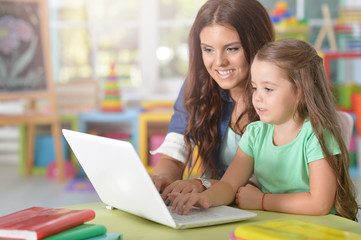 mother and daughter using laptop