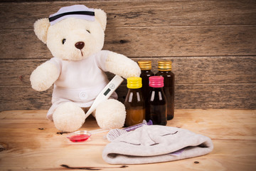 White teddy bear wear nurse with thermometer and medicine