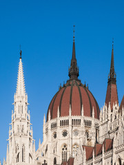 Obraz premium Detailed view of historical building of Hungarian Parliament, aka Orszaghaz, with typical central dome on clear blue sky background. Budapest, Hungary, Europe. It is notable landmark and seat of the