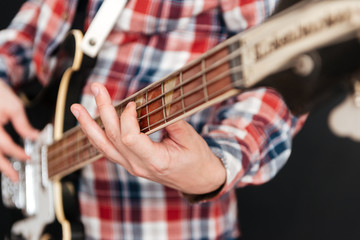 Cropped photo of man playing on the guitar