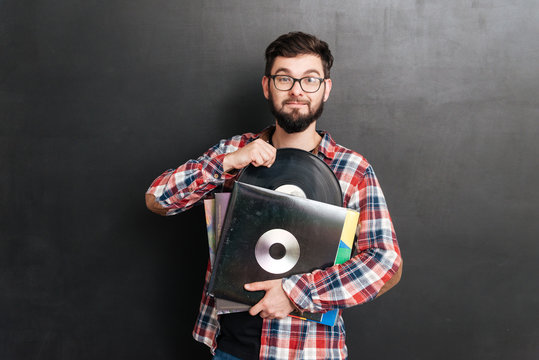 Cheerful Man Over Chalkboard Holding Vinyl Records In Hands