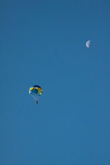 Parachute on background blue sky and the moon.