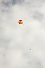 Aircraft and parachute on a background of clouds