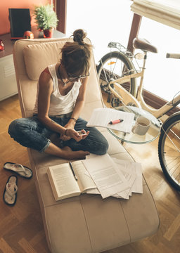 Woman at home with cell phone working on script