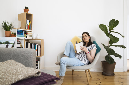 Woman at home sitting on chair looking up