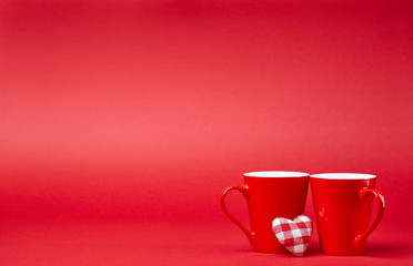 Red background with two cups and plush heart