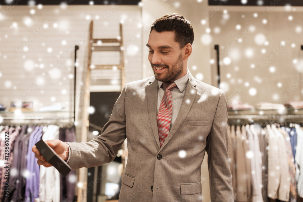 Wall mural happy man holding little box in clothing store