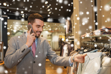 happy man calling on smartphone at clothing store