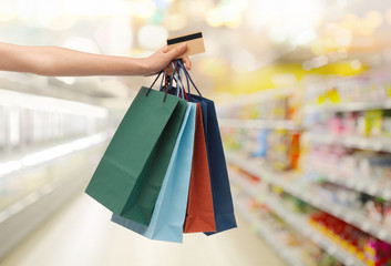 hand with shopping bags and credit card at store