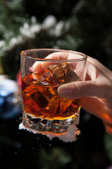Whiskey with ice on a winter background
