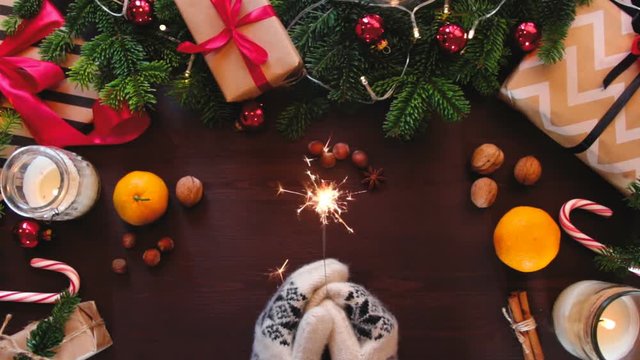 Top view of Christmas table decorated with a background of hands holding a Sparkler