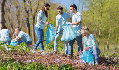 volunteers with garbage bags cleaning park area