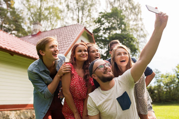 friends taking selfie at party in summer garden