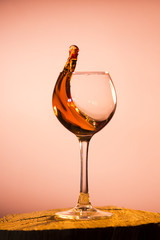 glass with cognac pouring out of him