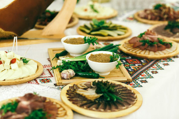 Wooden trays with snacks and sauces stand on white table