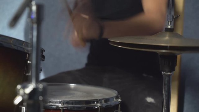 closeup details person playing on hi hat and drums kit. unrecognizable man wearing in casual jeans with hole and black t shirt.