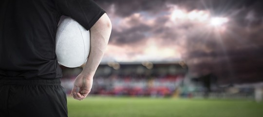 Composite image of rugby player holding a rugby ball