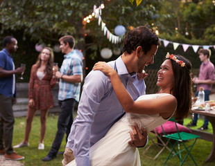 Young Couple Celebrating Wedding With Party In Backyard