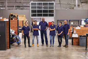 Portrait Of Engineers And Apprentices In Busy Factory