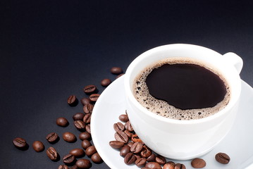 cup of coffee with coffee beans on a black background