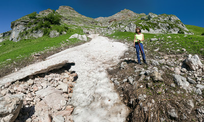 Female hiking woman happy and smiling during trek in Caucasus mountains, Fisht Region. Beautiful young mixed race sporty model climbing