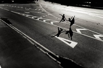 young woman and man performing gymnastic exercises on the road