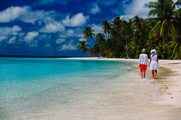 Fototapeta na wymiar happy loving couple walking on tropical beach
