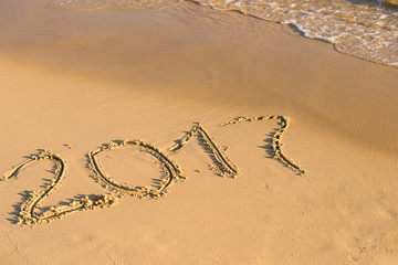 2017 year of the awakening - Numbers of the date 2017 drawn on the sand at the beach with a soft wave touching the shore. 2017, message written in the sand at the beach background. 2017 on seashore
