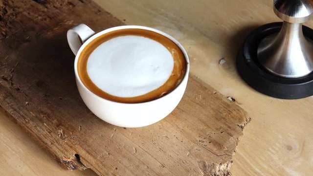 Barista making art graphic on milk flat coffee cappuccino by caramel sauce