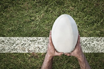 Composite image of man holding rugby ball