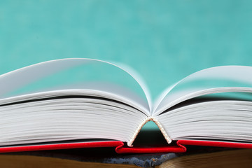 Open book, stack of hardback books. Back to school.