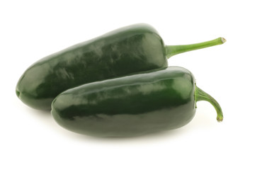 two whole green jalapeno peppers on a white background