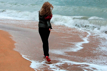 Slim, beautiful girl running on the beach